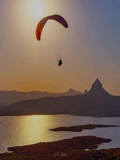 Paragliding over Pawna Lake at sunset